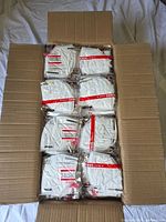 Cardboard box filled with individually packaged white KN95 masks