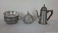 Group shot showing coffee pot, rabbit teapot, and stack of six bowls