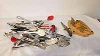 Pile of assorted utensils, cutting board, file