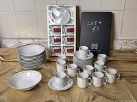 Overall photo shows 10 white bowls with gold trim, 10 espresso cups with matching saucers in two patterns, unopened espresso cup set in packaging.