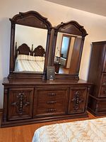 Front view of the vintage low boy dresser with double mirrors showing ornate woodwork and drawer/door details.