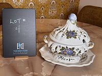 Soup tureen set on table with identification board