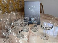 Set of 11 vintage drink glasses featuring Old Spaghetti Factory and Organ Grinder logos displayed on a marble table.