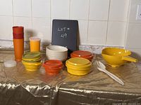 Photo showing entire vintage Tupperware lot on table with diverse pieces in various colors.