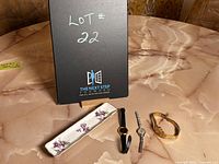 Photo showing three women's watches next to a Spode porcelain ring holder on a marble surface with a lot sign in background.