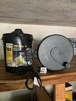 WAXX Pro 10-inch waxer polisher in bucket alongside the roll-up car cover on a shelf.