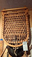 Front view of wooden chair backrest and seat showing woven lattice pattern and wooden frame.