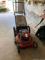 Front view of red Craftsman mower with Dust Blocker bag in garage