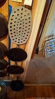 Side view of cast iron fry pans and trivet arranged on wall.