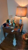 Overview of table showing two lamps and assorted glass items