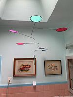 Retro hanging mobile with colorful discs suspended near ceiling.