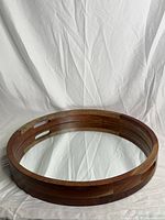 Front view of a circular mirror with a solid teak wood frame and reflective glass surface.