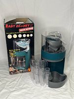 Motorized Easy Money II coin bank next to original box with removable coin tubes and coin tray visible.