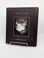 Front cover of the hardcover book titled 'Dreaming in Pictures: The Photography of Lewis Carroll' with a framed photograph of a girl in costume.