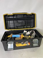 Stanley FatMax toolbox open, showing the tools inside including a blue and yellow caulking gun, mallet, and other items.