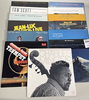 Photo showing 13 vinyl album covers stacked, featuring artists such as Tom Scott, Charles Mingus, Jean-Luc Ponty, and George Winston.