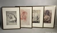 All four framed prints displayed side by side showing different nude figures and frames with visible wear