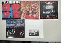 Five vintage vinyl record albums laid out on a table showing front covers of Talking Heads, The Rolling Stones, The Clash, Fine Young Cannibals, and The Long Ryders.