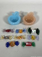 All items in the lot including two apple-shaped ashtrays and eight different Murano glass candy-shaped figurines