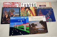 Eight vintage record albums including jazz and classical titles, laid out on a surface with covers visible