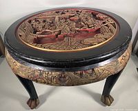 Overview photo of the round tea table showing carved top with black border and claw feet