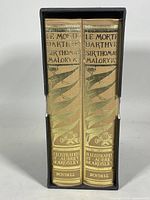 Two volumes of Le Morte Darthur set in original slipcase with gold foil designs on spine.