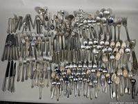 Overview of assorted vintage cutlery laid out including forks, knives, spoons, and specialty utensils