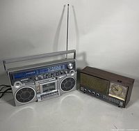 Both Toshiba RT-200S stereo radio cassette recorder and GE dual speaker clock radio side by side on a white surface with shadows.