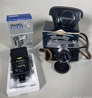 Konica Auto S2 film camera with Hexanon lens, leather case on original camera box and Starblitz 2000-BTZ flash with box and styrofoam packaging.