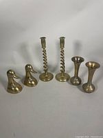 All items in the lot including candleholders, vases, and bookends arranged in one row on a white background.