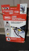 Bell 2 Bike Carrier box showing branding, capacity, and features including compatibility with most cars, vans, and SUVs