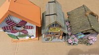 Top view of three bird houses showing flower-themed, school-themed, and rustic floral house details