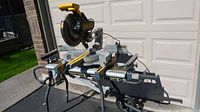 Front view of DEWALT sliding compound miter saw seated on RIDGID stand
