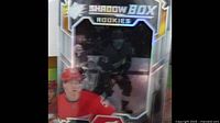 Close up of an Upper Deck Shadow Box Rookies hockey card with players in action and holographic design.