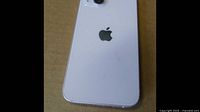 Back view of white iPhone 13 showing dual cameras and Apple logo with minor scratches