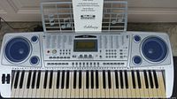 Full view of the Ashbury KB-200 61-key electronic keyboard showing keys, speakers, control panel, and music stand.
