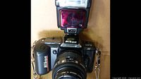 Front view of Nikon F-401 with attached lens and Nikon Speedlight 133P external flash mounted on top.