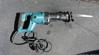 Full view of the Makita reciprocating saw showing blue and black color, corded power, and attached saw blade.
