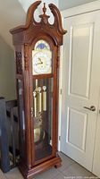 Full front view of grandfather clock showing case, bonnet and glass door.