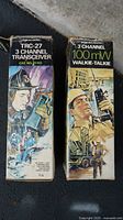 Two vintage Realistic TRC-27 3 channel transceiver boxes with illustrated artwork showing workers using the devices.