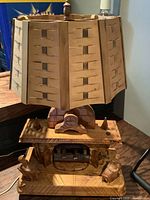 Lamp with wooden fireplace sculpture base and unlit woven wood lampshade