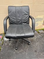 Front view of the black office chair showing padded backrest, seat, armrests, and rolling base.