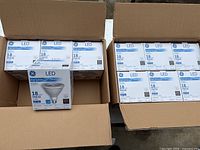 Image showing two opened boxes containing a total of 10 new GE LED PAR38 18W floodlight bulbs in their original packaging.