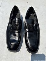 Top-front view of the two men's Guess black dress shoes showing overall shape and condition including some light creasing.