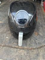 Top view of closed black Power XL air fryer showing unit body and silver handle.