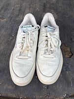 Front top view of the white Reebok sneakers showing toe box and laces.