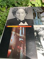 Four LPs laid out on table outdoors: Leonard Cohen I’m Your Man; Depeche Mode Some Great Reward; Depeche Mode Black Celebration; partial cover at bottom right.