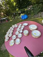 Overview of set laid out on table: cups, saucers, plates, bowls, platters