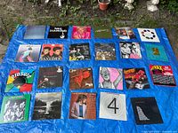 All 23 vinyl record sleeves laid out on blue tarp