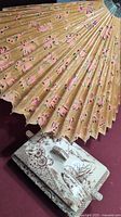 Photo showing the rice paper umbrella with small wooden ribs, decorated with pink floral patterns.